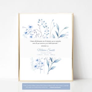 Peut inclure: Impression encadrée avec un cadre doré, présentant un motif aquarelle de fleurs bleues. Le texte en espagnol de Jérémie 1:5, un nom et des détails de naissance sont inclus: 19 octobre 2024, 23h30, 54 cm et 3500 g.