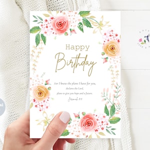Può includere: Biglietto di compleanno con un design floreale. La carta presenta le parole "Happy Birthday" in oro, circondate da rose e verde ad acquerello. È incluso anche il testo "For I know the plans I have for you..."