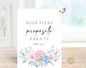 May include: A white card with the text "DIOS TIENE propósito PARA TI Ester 4:14" in black script. The card is decorated with watercolor flowers in pink, blue, and green. A small hummingbird logo is in the upper right corner.
