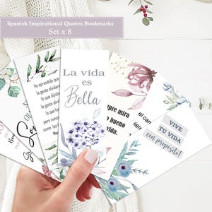 Puede incluir: Juego de ocho marcapáginas con citas inspiradoras en español. Cada marcapáginas presenta diseños florales en acuarela y citas en español. Los marcapáginas tienen un fondo blanco con varios colores, incluyendo azul, morado y verde.