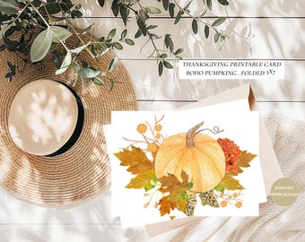 May include: Thanksgiving printable card featuring a watercolor illustration of a pumpkin, fall leaves, and flowers. The card is folded and measures 5x7 inches. The design has a boho style and is available as an instant download.