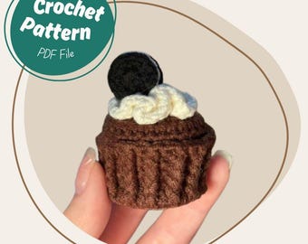 May include: A crocheted cupcake with a chocolate-colored base, cream-colored frosting, and a black cookie on top. The image includes a teal circle with the words "Crochet Pattern PDF File".