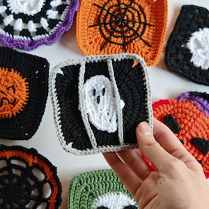 May include: Crocheted Halloween-themed coasters in various colors. Designs include a ghost, spiderwebs, and jack-o'-lanterns. The coasters are square and have a textured appearance, perfect for seasonal decor.