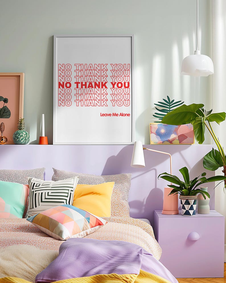 May include: A bedroom scene with a bed featuring colorful pillows and bedding. A framed print on the wall reads "NO THANK YOU" in red text. The room is decorated in pastel colors with a nightstand and a potted plant.