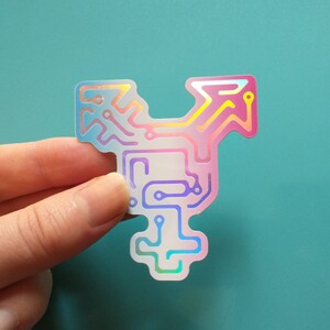 May include: A holographic sticker with a circuit board design in pink, blue, and purple colors. The circuit board design resembles a transgender symbol.