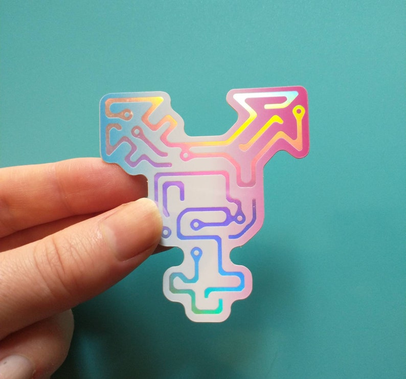 May include: A holographic sticker with a circuit board design in pink, blue, and purple colors. The circuit board design resembles a transgender symbol.
