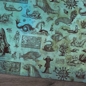 May include: A teal and blue patterned fabric featuring vintage illustrations of sea creatures, mermaids, and nautical elements. The design includes various sea monsters, ships, and underwater scenes, creating a whimsical and historical aesthetic.