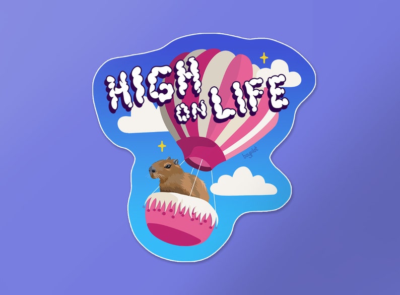 May include: A sticker featuring a cartoon capybara riding in a hot air balloon with the text "HIGH ON LIFE". The balloon is pink and white with a blue sky and clouds in the background.