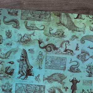 May include: A teal-colored paper with a vintage illustration of various sea creatures, including mermaids, sea serpents, and fish. The illustrations are in dark brown, creating a contrast against the teal background. The paper has a distressed, aged appearance.