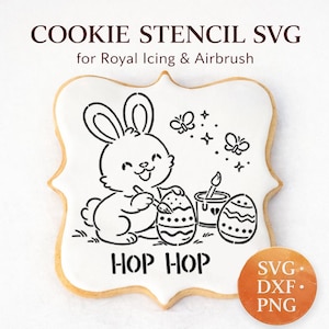 May include: A cookie stencil SVG for royal icing and airbrushing. The design features a bunny painting Easter eggs, with the text "HOP HOP". Includes SVG, DXXF, and PNG file formats. The cookie has a white icing and a golden-brown edge.