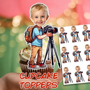 May include: Cupcake toppers featuring a cartoon illustration of a young child with a camera on a tripod. The child wears a blue shirt, khaki pants, and a backpack. The words "CUPCAKE TOPPERS" are in red and white text.