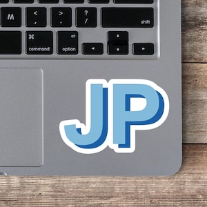 May include: A blue and white sticker with the letters "JP" on a silver laptop computer.