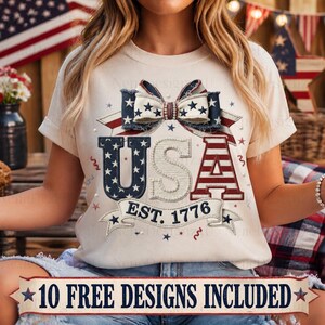 Op de afbeelding: Crèmekleurig T-shirt met een patriottisch USA-ontwerp. Het ontwerp heeft een strik met sterren, het woord "USA" in rood, wit en blauw en de tekst "EST. 1776". Een banner onderaan luidt "10 FREE DESIGNS INCLUDED".