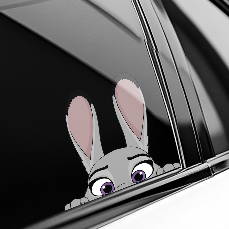 May include: A gray cartoon bunny peeking out from behind a car window. The bunny has large, pink-lined ears, purple eyes, and a slightly worried expression. The sticker is designed to be placed on a car window.