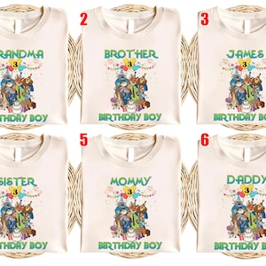 May include: Six off-white t-shirts featuring a colorful graphic of cartoon animals at a birthday party. Each shirt displays the number 3 inside a yellow circle, festive bunting, and the text BIRTHDAY BOY. The shirts are labeled 1 through 6.