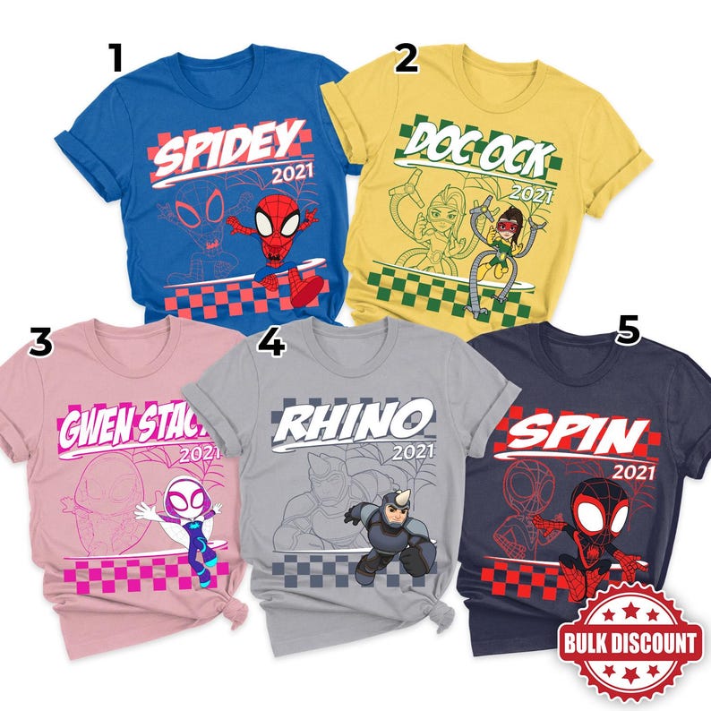 May include: Five short-sleeved t-shirts with superhero-themed graphics. The shirts are blue, yellow, pink, gray, and navy. Each shirt features a different character name and the year 2021. A red and white bulk discount sticker is in the bottom right corner.