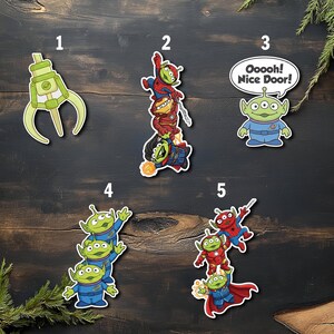 May include: A collection of colorful stickers featuring characters from Toy Story and Marvel. Designs include a green claw, aliens, and superheroes like Spider-Man and Iron Man. One sticker has the text "Ooooh! Nice Door!"