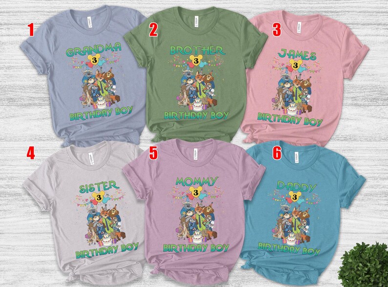May include: Six short-sleeved crew neck t-shirts in light blue, olive green, pink, light gray, lavender, and teal. Each shirt features a graphic of animated animal characters, a birthday cake, balloons, and the text "BIRTHDAY BOY" with a number 3.