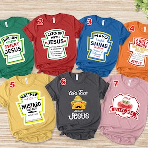 May include: A collection of seven short-sleeved t-shirts in various colors, each featuring a unique graphic design resembling condiment labels. The designs include phrases like "Sweet Jesus," "Catch Up With Jesus," and "Let's Taco About Jesus."