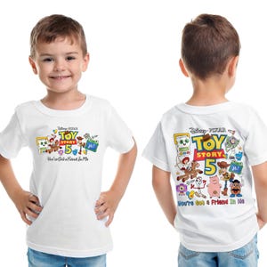 May include: White short-sleeved t-shirt featuring a colorful graphic of Toy Story characters and the text "TOY STORY 5". The shirt also includes the phrase "You've Got a Friend In Me".