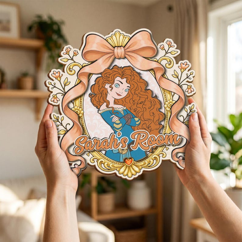 May include: A decorative wooden wall sign featuring a cartoon illustration of a girl with long curly red hair in a blue dress, framed by an ornate gold border and a large peach-colored ribbon, with the text Sarah's Room printed in brown.