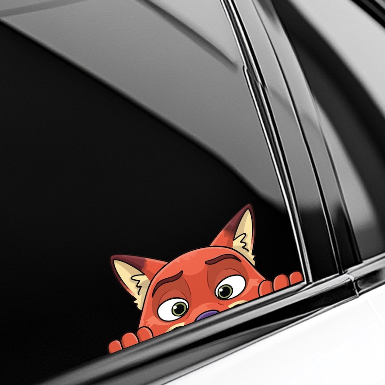 May include: A car window decal featuring a cartoon fox with orange fur, green eyes, and a worried expression. The fox is peeking over the edge of the window, with its paws visible. The decal is designed to be applied to a car window.