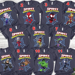 Puede incluir: Una colecci&oacute;n de once camisetas azul marino con varios personajes de la serie animada "Spidey y sus sorprendentes amigos". Cada camiseta muestra un personaje diferente sobre un fondo de telara&ntilde;a, con el logotipo del programa en rojo y azul.