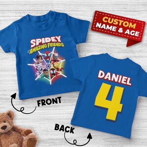 May include: Blue t-shirt featuring the text "Spidey and His Amazing Friends" with character graphics. The back of the shirt has the name "Daniel" and the number "4" in yellow. A red banner reads "Custom Name & Age."