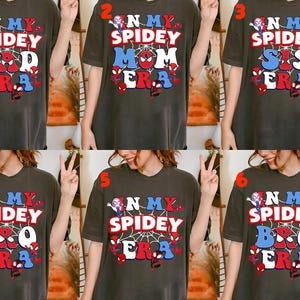 May include: Dark gray t-shirts with the text "N My Spidey Dad Era", "N My Spidey Mom Era", "N My Spidey Sis Era", "N My Spidey Bro Era", "N My Spidey Era". Each shirt features a Spider-Man theme with red, white, and blue accents.