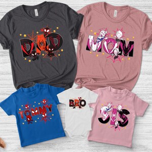 Puede incluir: Una colecci&oacute;n de camisetas y un body con dise&ntilde;os de superh&eacute;roes. Las camisetas son de varios colores, incluyendo gris, rosa y azul, con las palabras "DAD", "MOM", "TOMMY", "BRO" y "SIS" en letras negritas. Cada dise&ntilde;o incluye personajes de superh&eacute;roes y telara&ntilde;as.