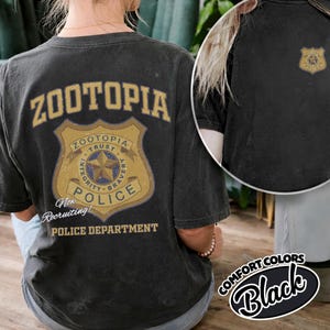 Puede incluir: Camiseta negra con la palabra "Zootopia" encima de una insignia de polic&iacute;a. La insignia incluye las palabras "Trust, Integrity, Bravery" y "Police". Tambi&eacute;n se ve el texto "Now Recruiting!" y "Police Department".