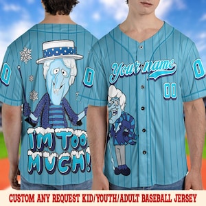 May include: Light blue baseball jersey with a cartoon character design. The jersey features a v-neck, pinstripes, and the text "Your name" above the number "00". The back of the jersey has the phrase "I'M TOO MUCH!" and a cartoon character.
