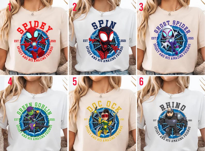 Puede incluir: Seis camisetas con personajes de Spider-Man. Cada camiseta muestra el nombre de un personaje, como "Spidey" o "Rhino", dentro de un dise&ntilde;o de telara&ntilde;a, junto con el texto "Spidey and His Amazing Friends" y el a&ntilde;o "2021".