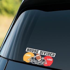 May include: A car window decal with the text "HOUSE DIVIDED". The decal features a football, two helmets, and the word "LOGO" on the yellow and red helmets. The football is brown and white.