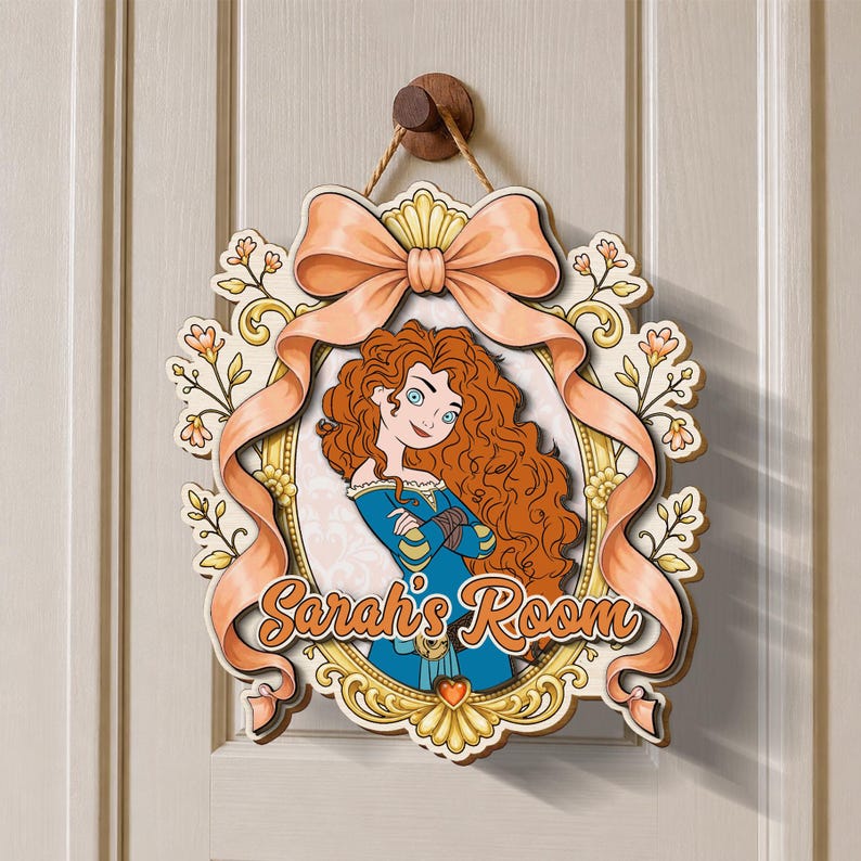 May include: A decorative wooden door sign featuring a cartoon illustration of a girl with long curly red hair in a blue dress, framed by a gold border and a large peach-colored ribbon. The text Sarah's Room is printed in orange script.