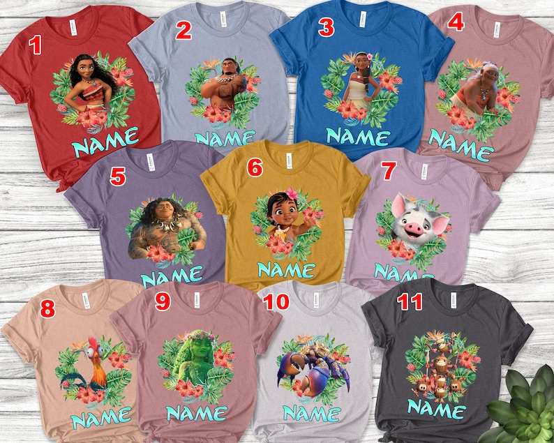 K&ouml;nnte beinhalten: Elf kurz&auml;rmelige T-Shirts in verschiedenen Farben, jeweils mit einer Figur aus einem beliebten Animationsfilm. Jedes Shirt hat ein Charakterbild, das von einem Blumengirlande umgeben ist, und darunter das Wort "NAME".