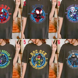 Puede incluir: Camisetas de color gris oscuro con varios personajes de Spider-Man. Cada camiseta tiene un gr&aacute;fico circular con el nombre de un personaje y el texto "SPIDEY AND HIS AMAZING FRIENDS". Los personajes incluyen a Spider-Man, Spin, Ghost Spider, Green Goblin, Doc Ock y Rhino.