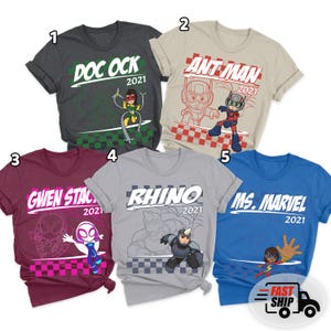 May include: Five graphic t-shirts featuring comic book characters. Designs include "Doc Ock," "Ant-Man," "Gwen Stacy," "Rhino," and "Ms. Marvel," each with the year "2021." The shirts are in various colors, including gray, tan, burgundy, and blue.