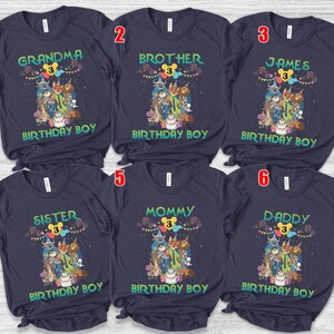 May include: Six dark navy blue short-sleeve t-shirts featuring a colorful graphic of cartoon animals, a birthday cake, and balloons. Each shirt displays a unique title: Grandma, Brother, James, Sister, Mommy, or Daddy, with the text Birthday Boy.