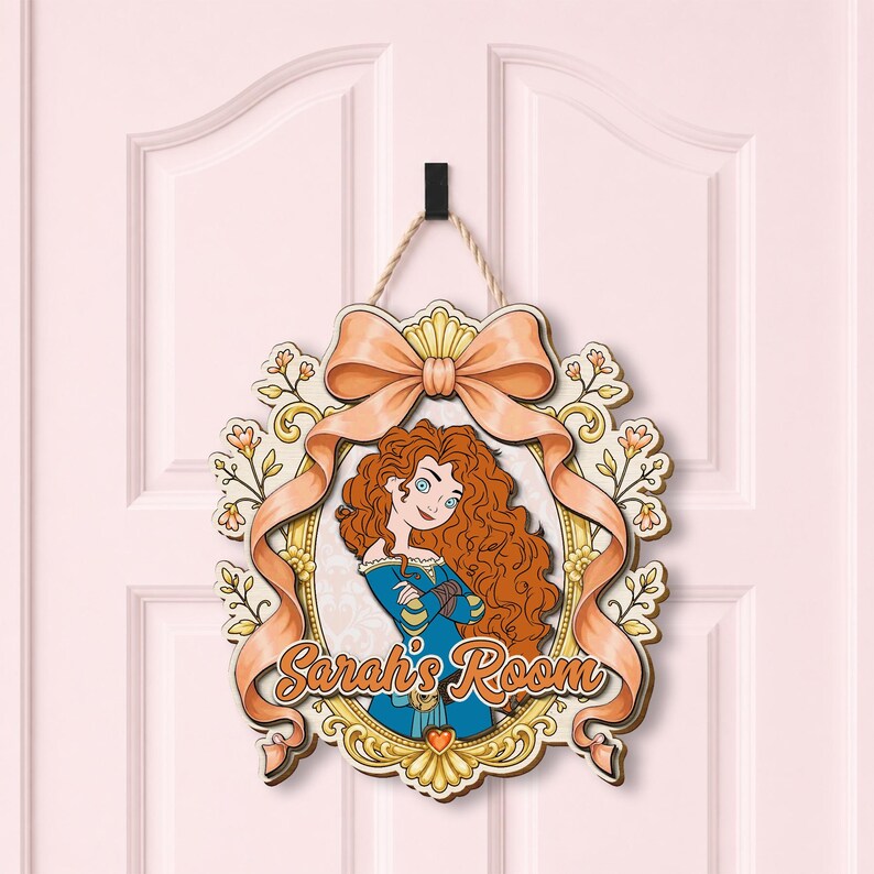 May include: A decorative wooden wall sign featuring a cartoon illustration of a character with long curly red hair in a blue dress, framed by a gold border and a peach-colored ribbon. The text "Sarah's Room" is printed in orange script at the bottom.