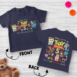 May include: Navy blue children's t-shirt featuring a colorful graphic from Disney Pixar's Toy Story 5. The front of the shirt displays the text "Toy Story 5" and "You've Got a Friend in Me". The back of the shirt also has the same graphic.