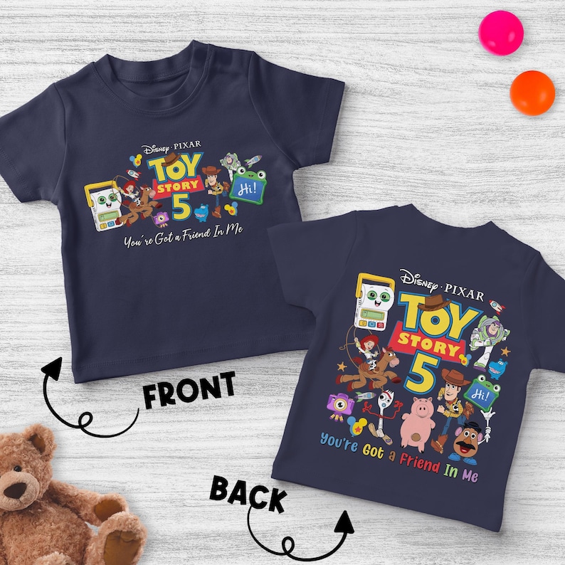 May include: Navy blue children's t-shirt featuring a colorful graphic from Disney Pixar's Toy Story 5. The front of the shirt displays the text "Toy Story 5" and "You've Got a Friend in Me". The back of the shirt also has the same graphic.