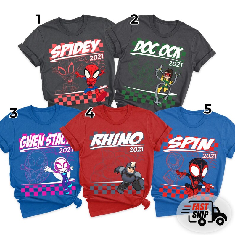 May include: Five colorful t-shirts featuring superhero-themed graphics. The shirts are in various colors: charcoal, dark grey, blue, red, and royal blue. Each shirt has a different character name and the year 2021 printed on it. The shirts are for sale.