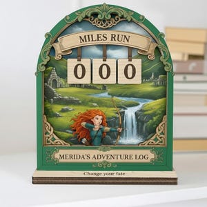 May include: A wooden adventure log with a green frame and a landscape painting featuring a waterfall and a character with red hair aiming a bow and arrow. The text "MILES RUN" and "MERIDA'S ADVENTURE LOG" are displayed. The counter reads "000". The phrase "Change your fate" is at the bottom.