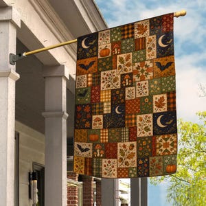 May include: A rectangular outdoor flag featuring a patchwork design of autumn-themed squares. The pattern includes illustrations of orange pumpkins, brown acorns, red mushrooms, colorful fall leaves, black bats, and yellow crescent moons on dark backgrounds.