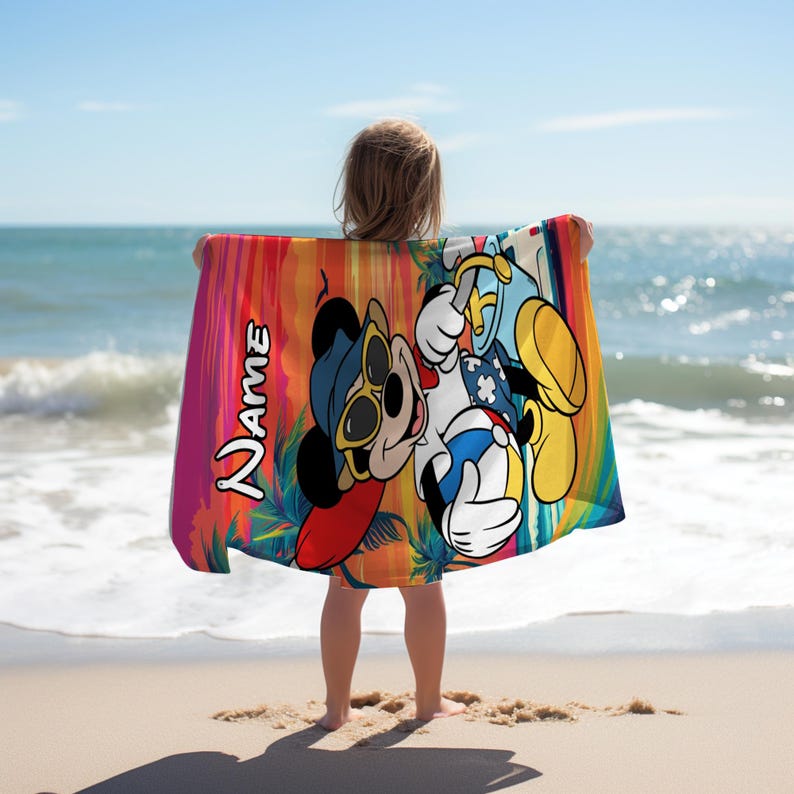 May include: A rectangular beach towel featuring a colorful sunset background with palm tree silhouettes. The towel displays a cartoon mouse wearing sunglasses and holding a beach ball, with the word Name printed vertically in white text.