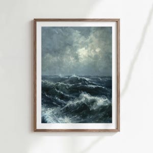 May include: A framed print of a seascape painting. The artwork depicts a turbulent ocean with large waves under a stormy, overcast sky. The color palette is dominated by shades of blue, gray, and white, creating a dramatic and moody atmosphere.