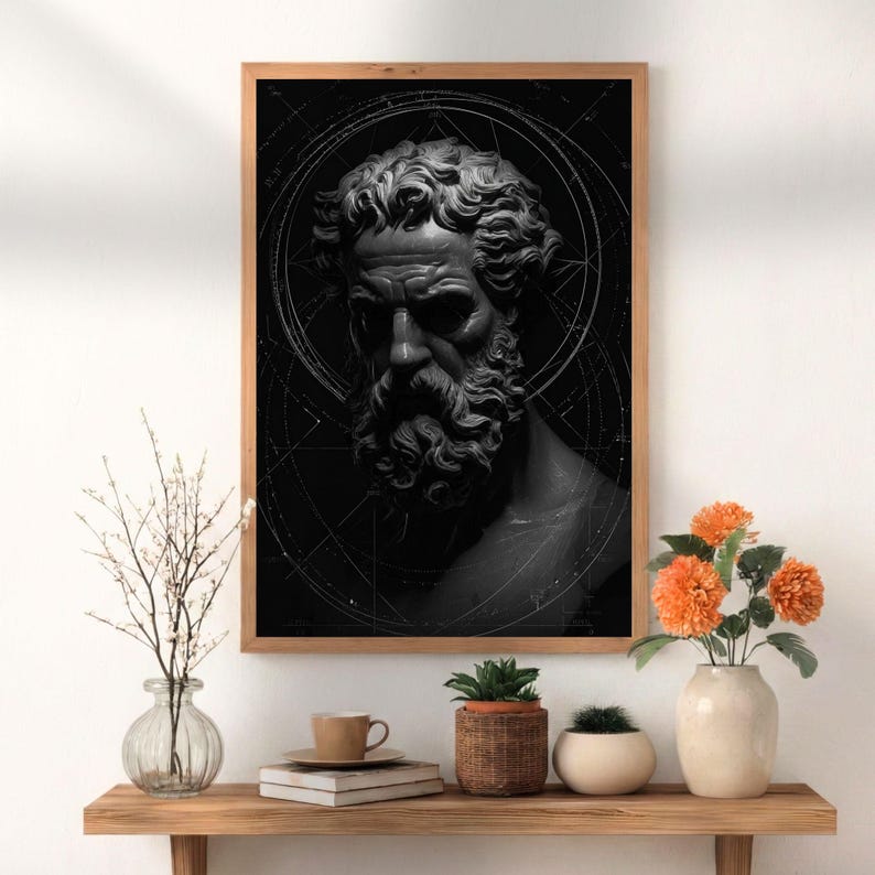 May include: A framed black and white print of a classical bust with a detailed beard and curly hair. The artwork is set against a dark background with geometric lines, framed in a light brown wooden frame.