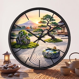 May include: A round wall clock with a black frame featuring a printed scene of a Japanese zen garden with a raked sand pattern, a stone water basin with a bamboo dipper, a bonsai tree, a large mossy rock, and a distant mountain at sunset.