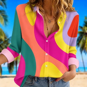 Peut inclure: Une chemise boutonnée avec un motif abstrait vibrant. La chemise à manches longues présente un motif coloré de formes courbes dans les tons de rose, orange, jaune, vert et violet. Les poignets sont de couleur rose clair.